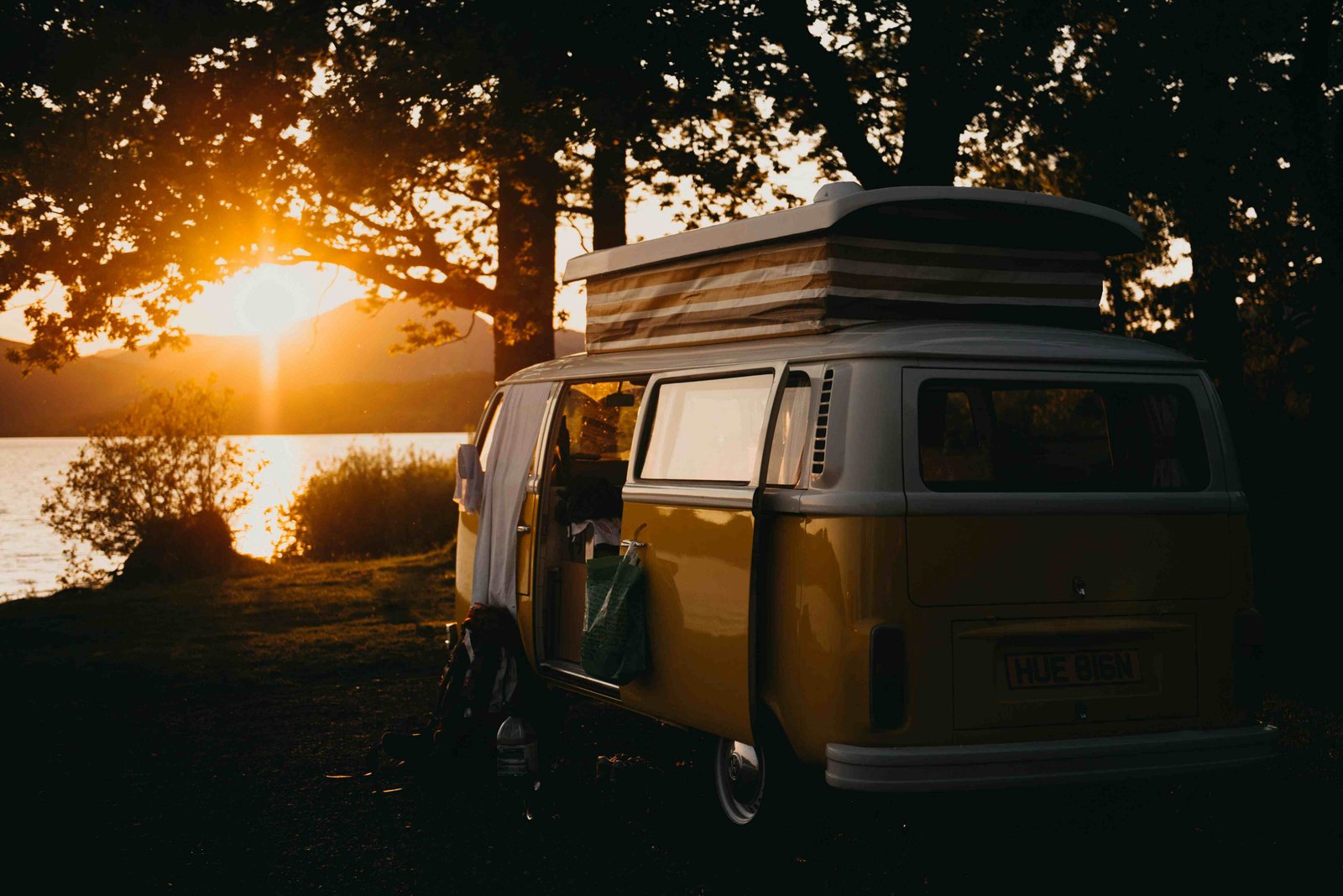 Campervan beside a lake at sunset